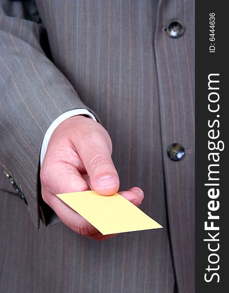 Businessman offering yellow business card. Businessman offering yellow business card