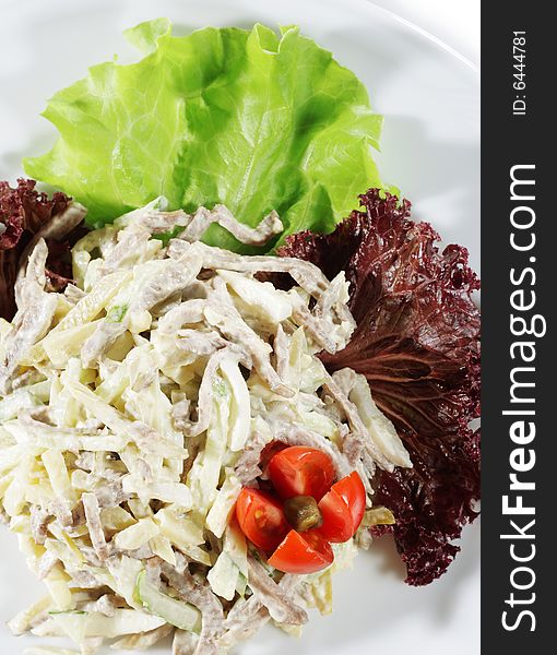 Salad from Beef and Vegetables. Serve on a Plate with Tomato and Greens. Isolated over White
