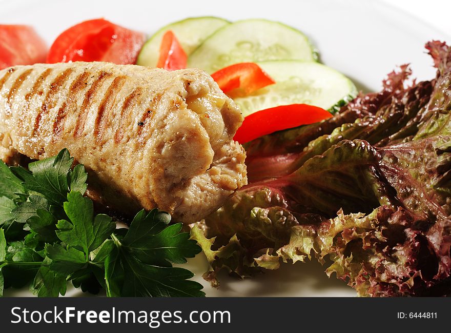 Pork (or Beef) Grilled Roll with Greens and Vegetables on a Plate. Isolated on White Background. Pork (or Beef) Grilled Roll with Greens and Vegetables on a Plate. Isolated on White Background