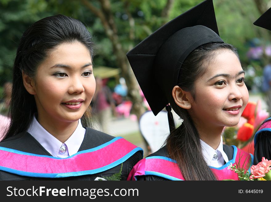 Beautiful Asian university graduates celebrate their success.