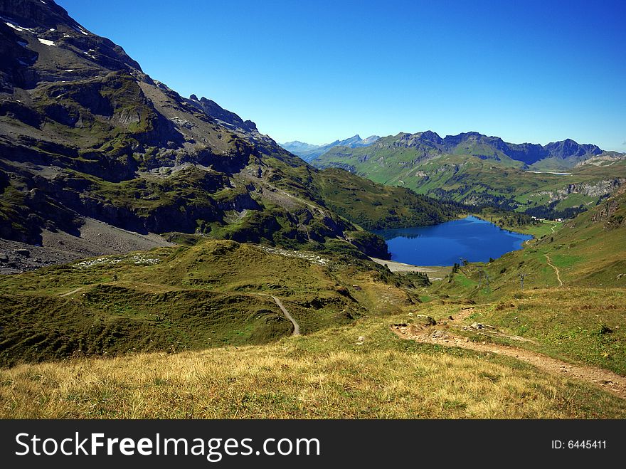 The valley and small lake in swiss mountains. The valley and small lake in swiss mountains