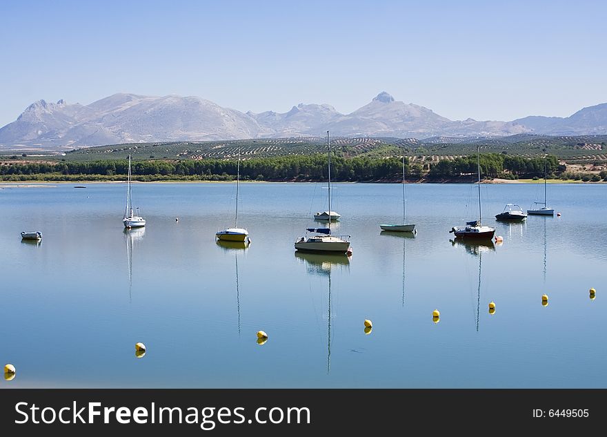 Some yatchs in a lake under blue sky. Some yatchs in a lake under blue sky.