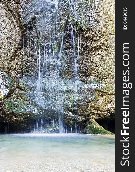 Long exposed waterfall falling in clear waters.