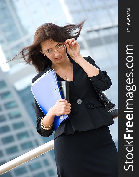 Business woman with documents outside a modern office building