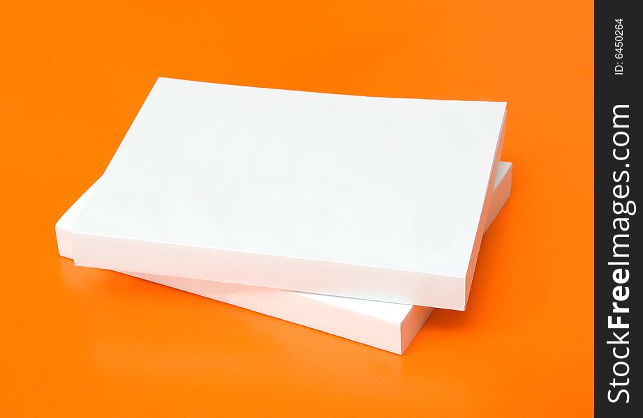 Two blank books over an orange background