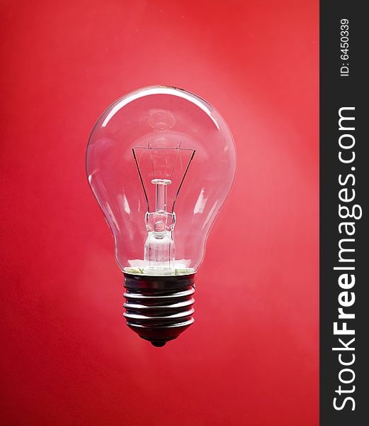 Single light bulb isolated on red background. Single light bulb isolated on red background