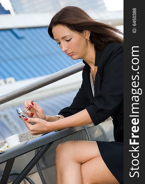 Business woman using palmtop outdoors