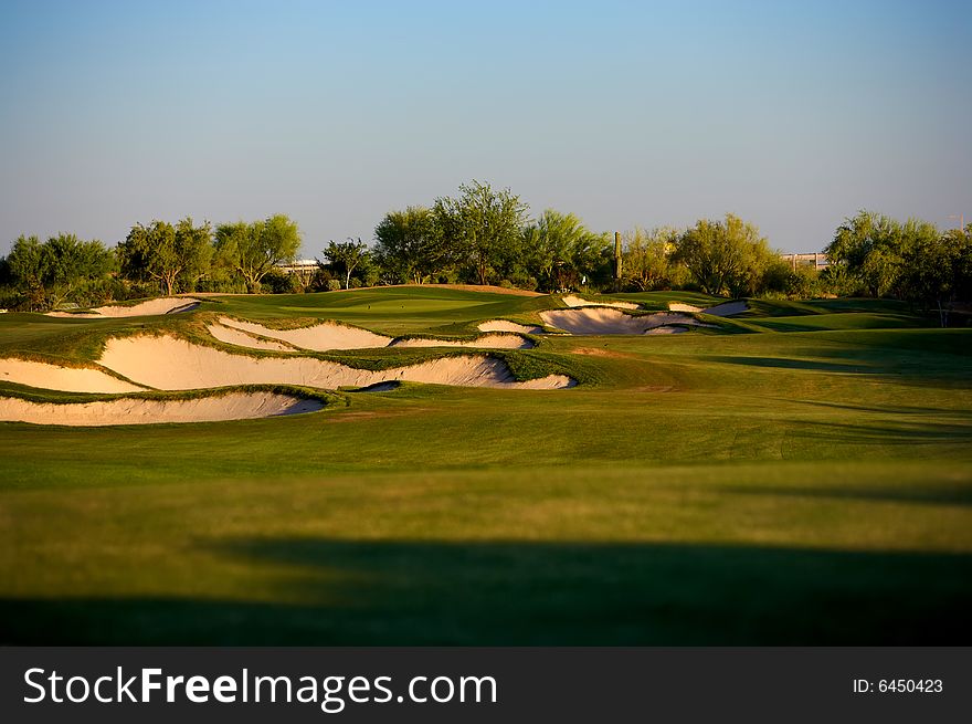 Golf course in the Arizona desert with mountains in the late afternoon sun