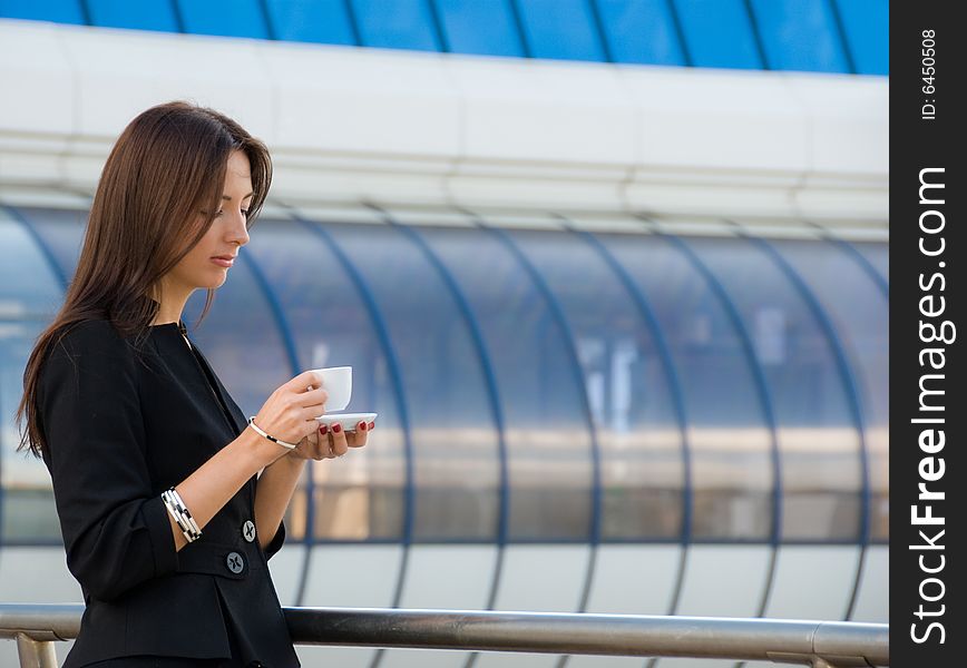 Business woman drinks a coffee outdoors in modern downtown. Business woman drinks a coffee outdoors in modern downtown