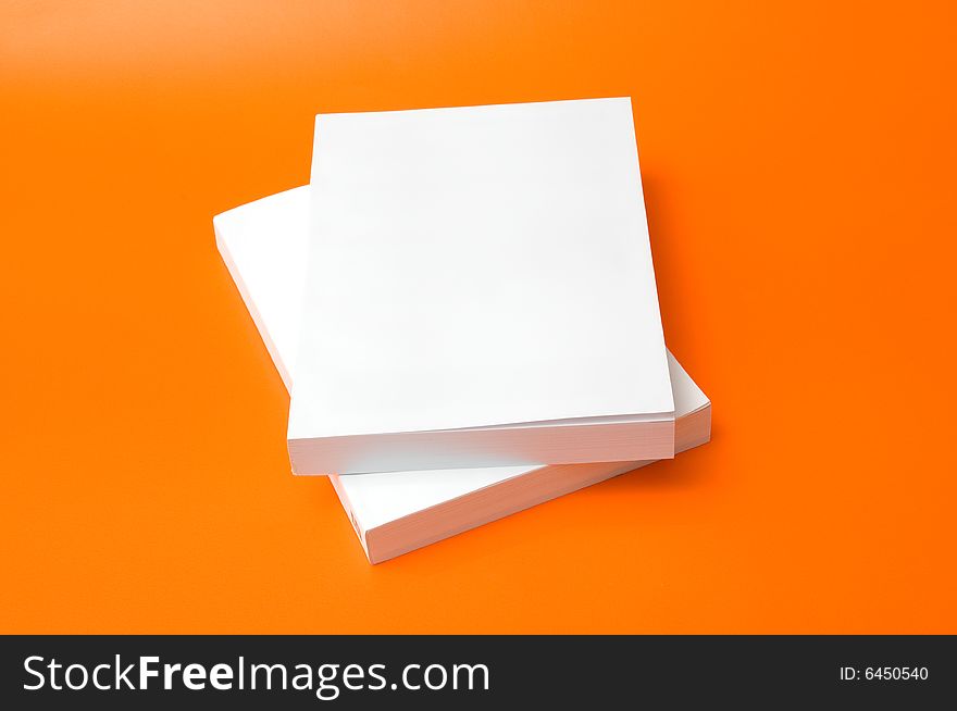 Two blank books over an orange background