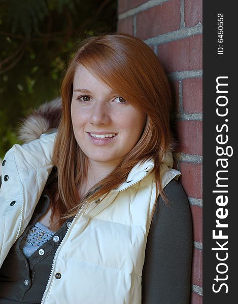 Attractive girl smiles at camera. She is wearing a white vest. Vertically framed photo. Attractive girl smiles at camera. She is wearing a white vest. Vertically framed photo.