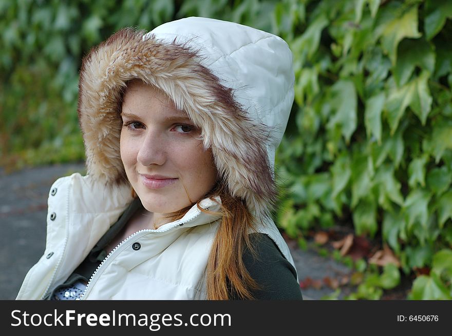Attractive girl smiles at camera. She is wearing a white hood. Horizontally framed photo. Attractive girl smiles at camera. She is wearing a white hood. Horizontally framed photo.