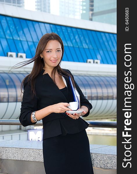 Business woman drinks a coffee outdoors in modern downtown. Business woman drinks a coffee outdoors in modern downtown