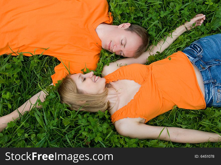 Loving couple lies side by side on the grass