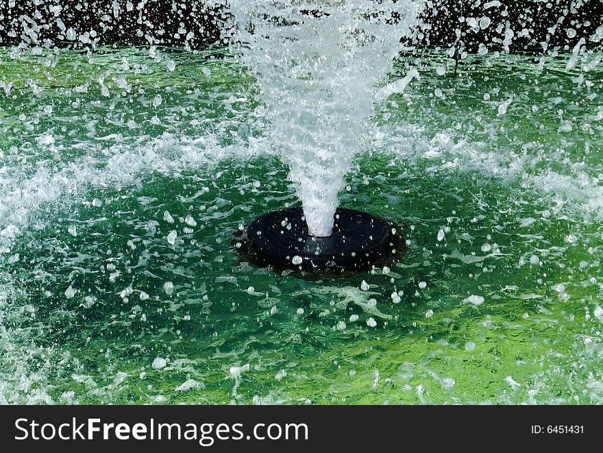 Abstract Closeup of Public Fountain with High Spray of Green Water. Abstract Closeup of Public Fountain with High Spray of Green Water