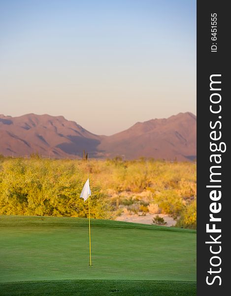 Golf course in the Arizona desert with mountains in the late afternoon sun