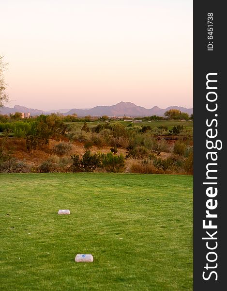 Golf course in the Arizona desert with mountains in the late afternoon sun