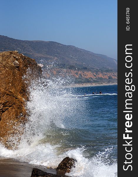 Wave crashing into rock on a beach