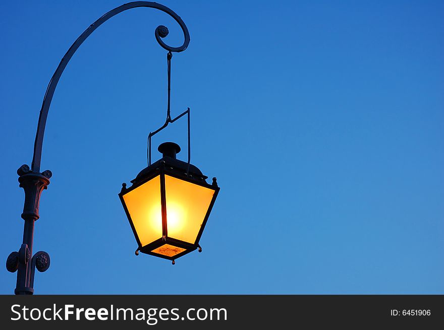 Lantern on a pillar on a background of the dark blue sky. Lantern on a pillar on a background of the dark blue sky