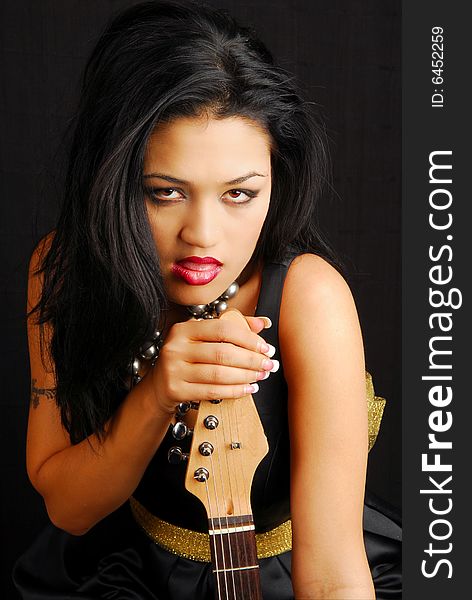 Beautiful hispanic woman with a seductive look holding her guitar. Beautiful hispanic woman with a seductive look holding her guitar