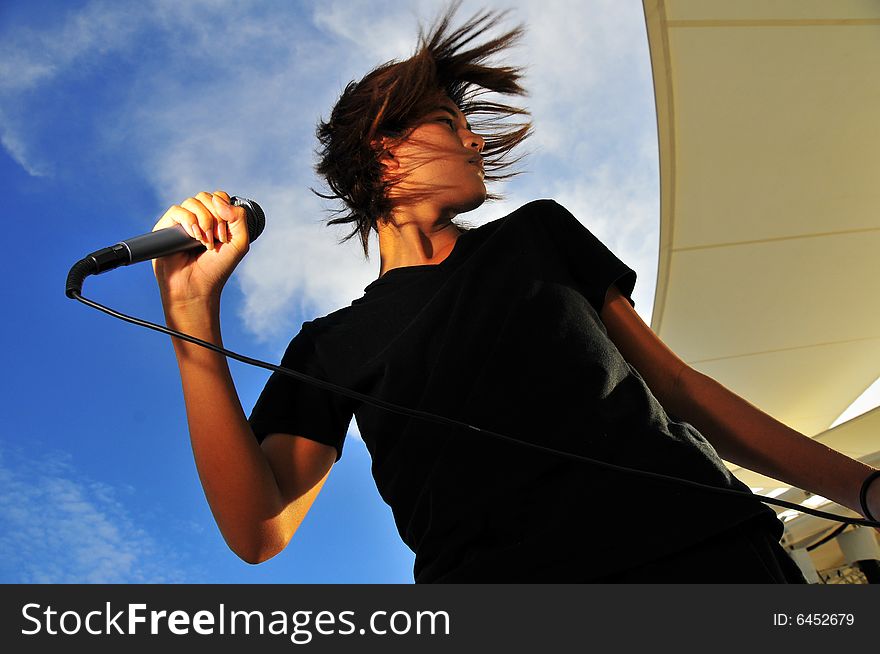 Picture of a young generation rock star with a microphone. Suitable for musical related contexts. Picture of a young generation rock star with a microphone. Suitable for musical related contexts.