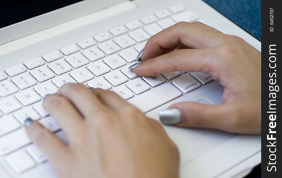 Hands typing on laptop keyboard