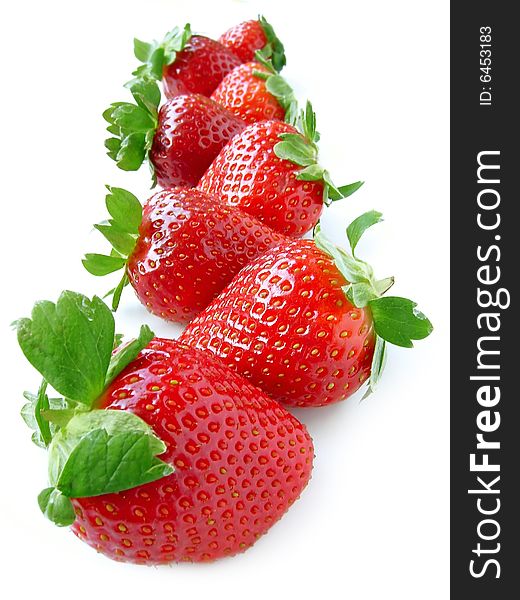 A lot of ripe strawberries in row isolated on white. A lot of ripe strawberries in row isolated on white