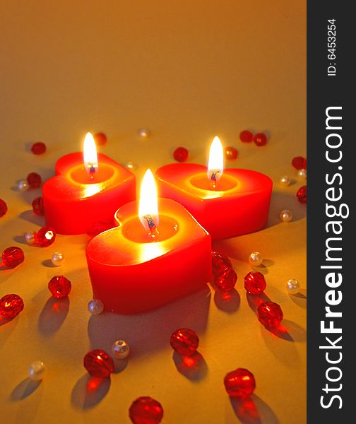 Three burning red heart candles. Three burning red heart candles