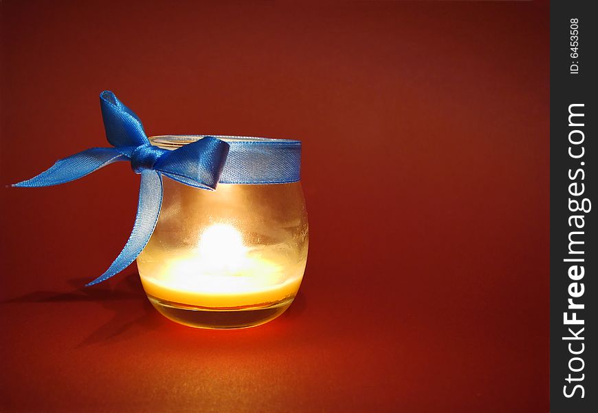Candle in glass bottle with blue bow