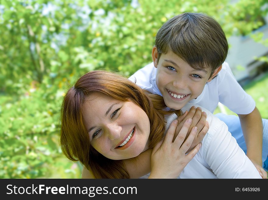 Portrait of happy mother with her son in summer environment