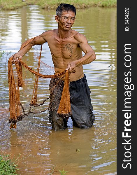 Fisherman of Thailand with throw net, in the water with the fishing