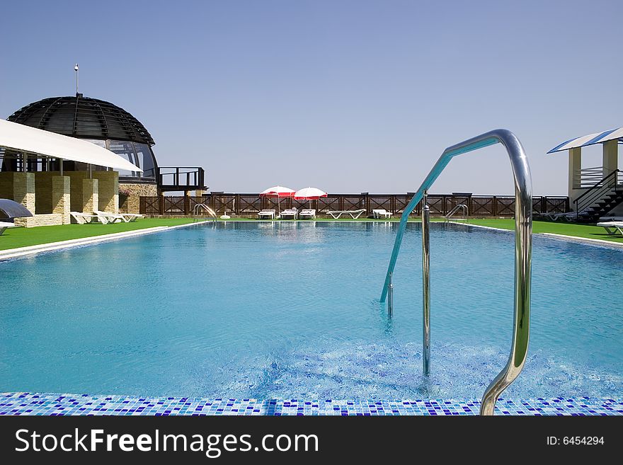 Swimming pool in luxury hotel at hot summer day