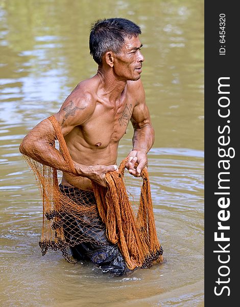 Fisherman of Thailand with throw net, in the water with the fishing
