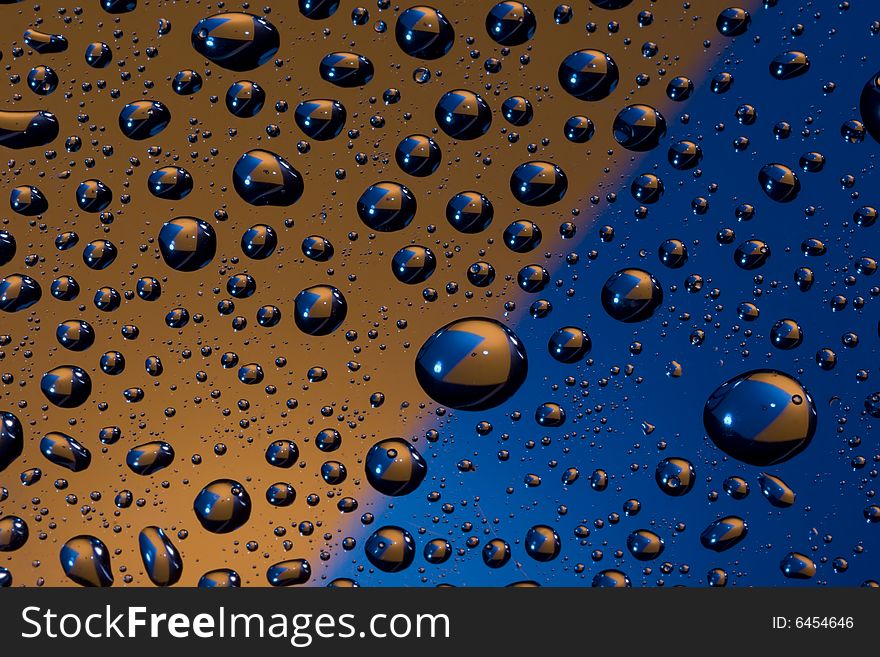 Water drops with a colorful background showing through. Water drops with a colorful background showing through.