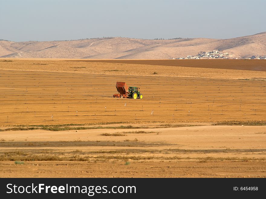 Tractor seeding a fallow ploughed field