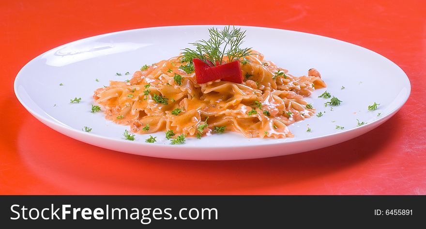 Freshly cooked plate of macaroni decorated with fresh green herbs