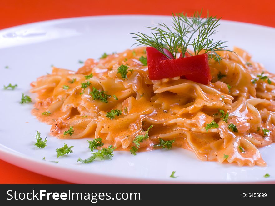 Freshly cooked plate of macaroni decorated with fresh green herbs