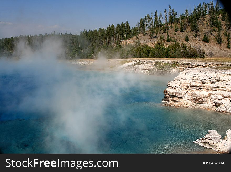 Blue lake with geysers in Yellowstone National Park
