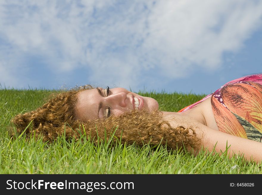 Woman in the grass under the clouds