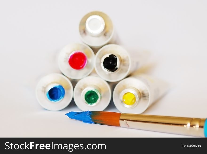 Red, blue, green, yellow, black and white gouache colors with the brush in white background. Red, blue, green, yellow, black and white gouache colors with the brush in white background