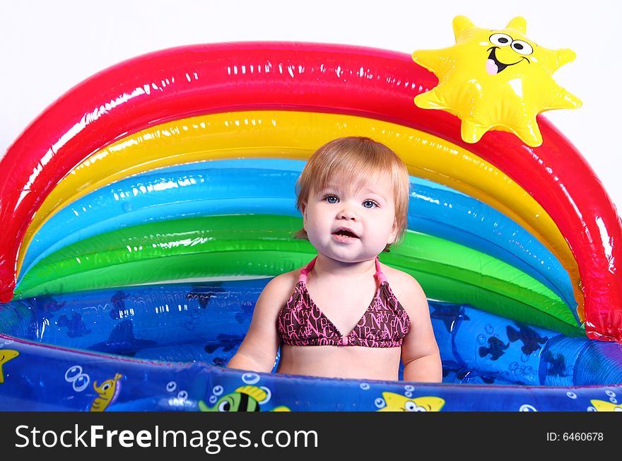 An adorable baby girl plays in her pool. An adorable baby girl plays in her pool.
