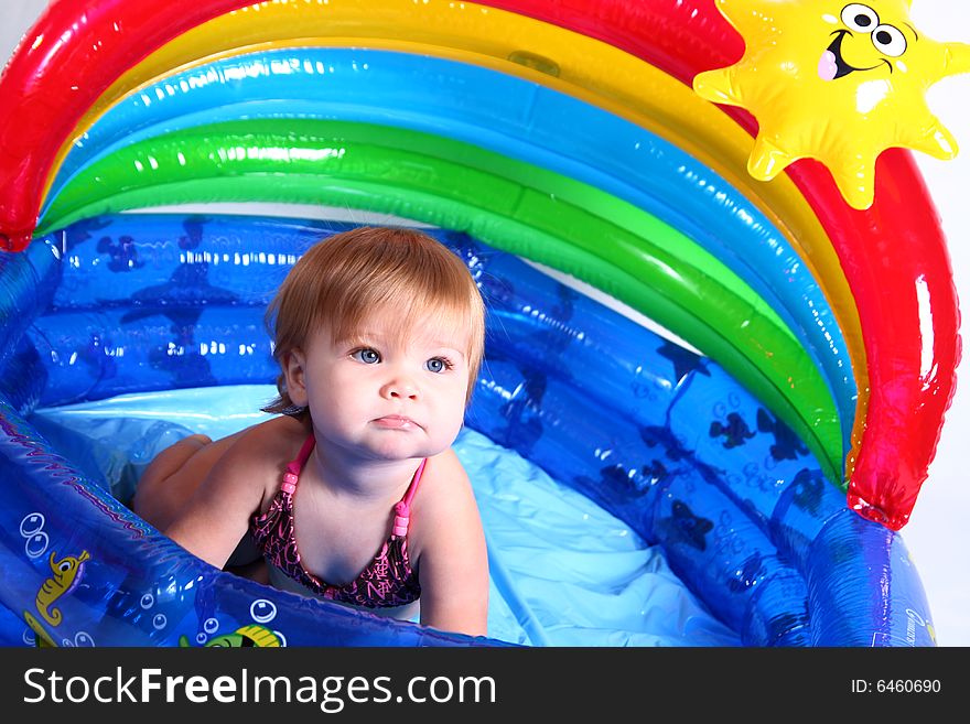 An adorable baby girl plays in her pool. An adorable baby girl plays in her pool.