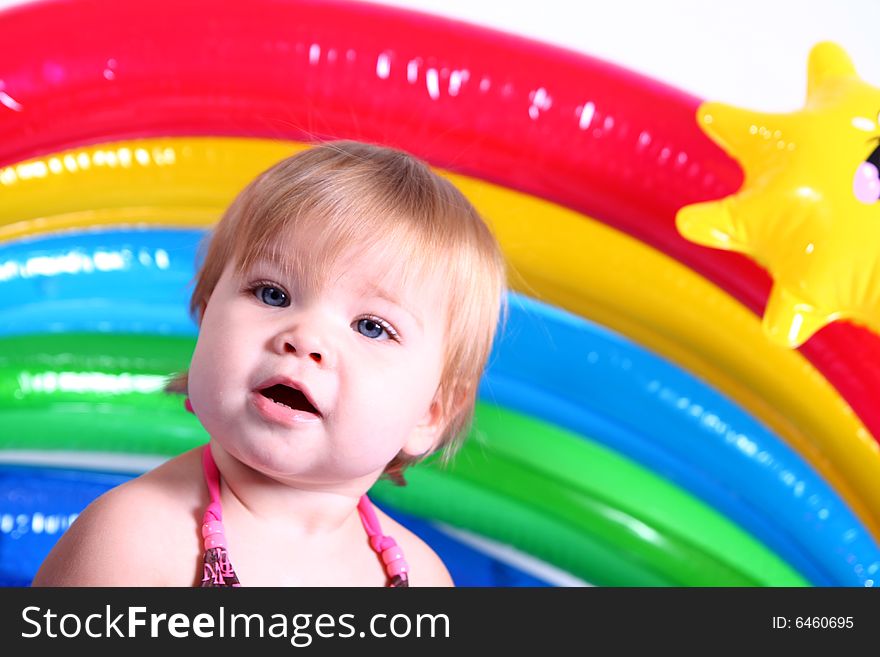 An adorable baby girl plays in her pool. An adorable baby girl plays in her pool.