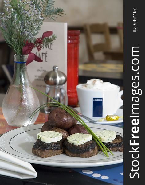 Steak medallions with herb butter and baked potatoes