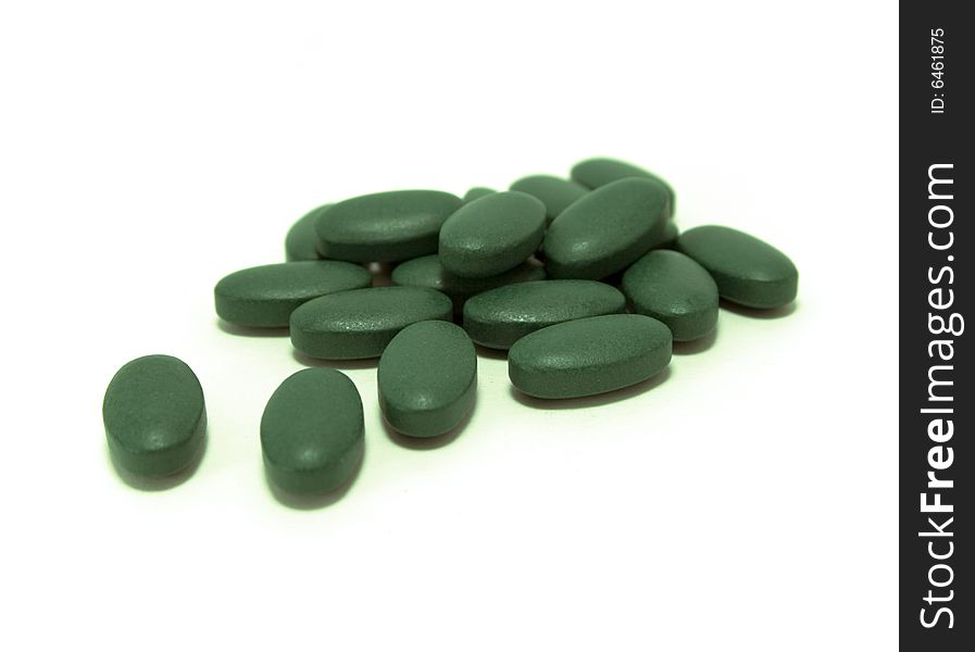 Green pills on white background. Green pills on white background