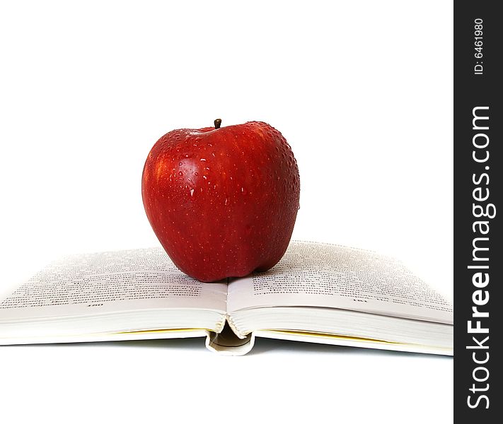 Red apple on the book isolated background