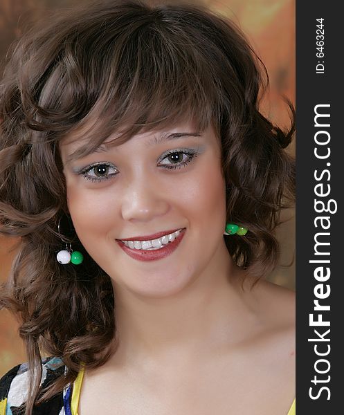 Portrait of the beautiful girl in studio on a brown background