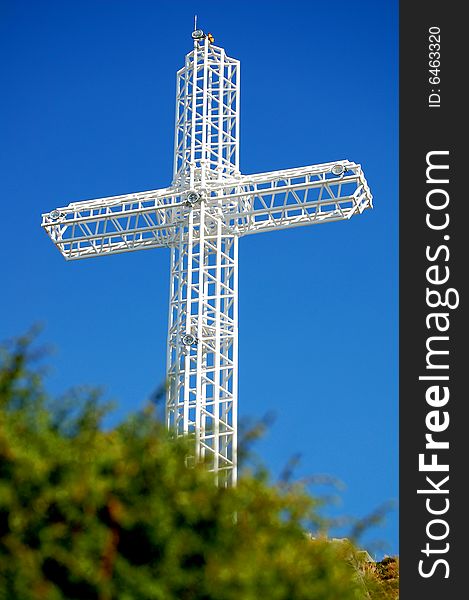 White steel cross on top of the mountain