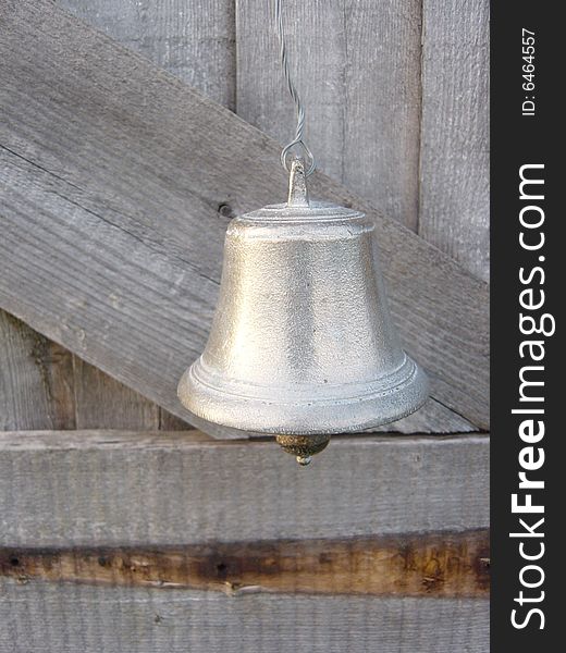 A small silver bell hanging on a door
