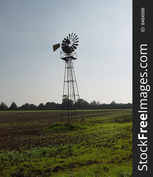 A Wind Generator on an english Farm on a sunny day.